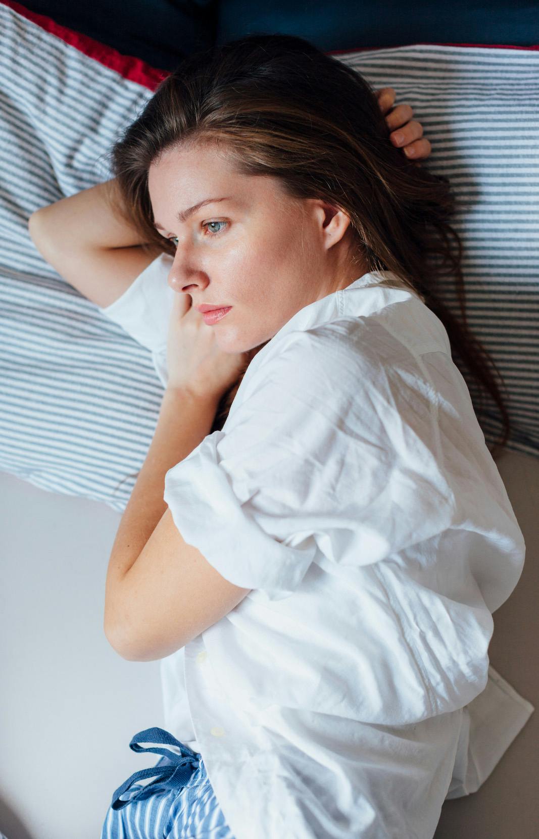 Mujer acostada en cama con gripe, incapaz de hacer nada