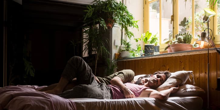 Peaceful portrait of a gay couple sleeping on bed during the morning.