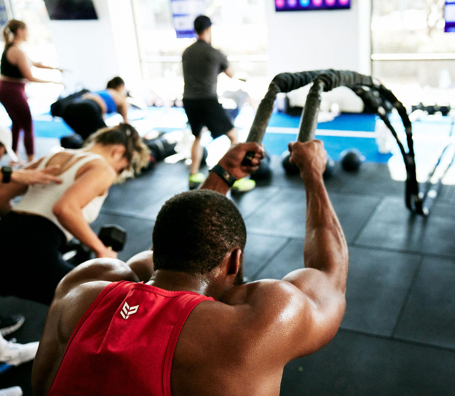 Hombre en el gimnasio F45 Training trabajando con cuerdas pesadas