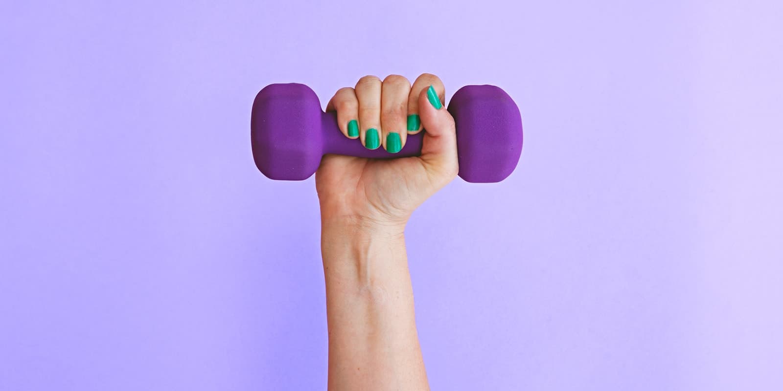 Una mano con las uñas pintadas que sostiene una pequeña pesa