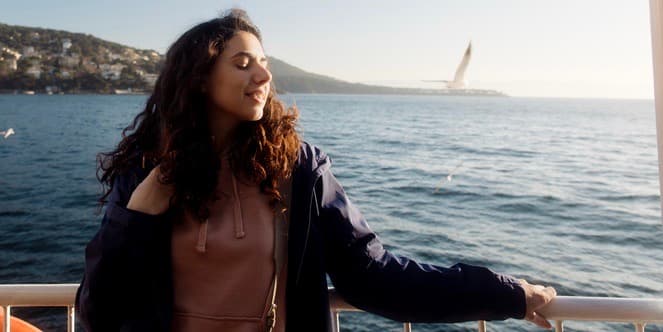 A young woman is sailing on a ferry and admiring the Bosphorus. Seagulls fly in the background. marble sea. Istanbul.